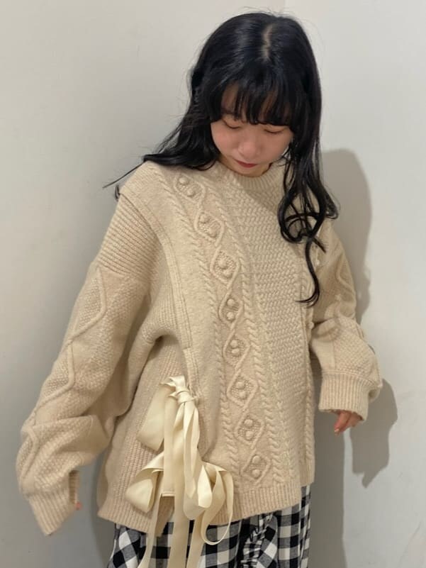 ブラック系のスカート、ブルー系のブーツ、ホワイト系のニット/セーターを着用したレディースの秋コーディネートの5枚目の写真