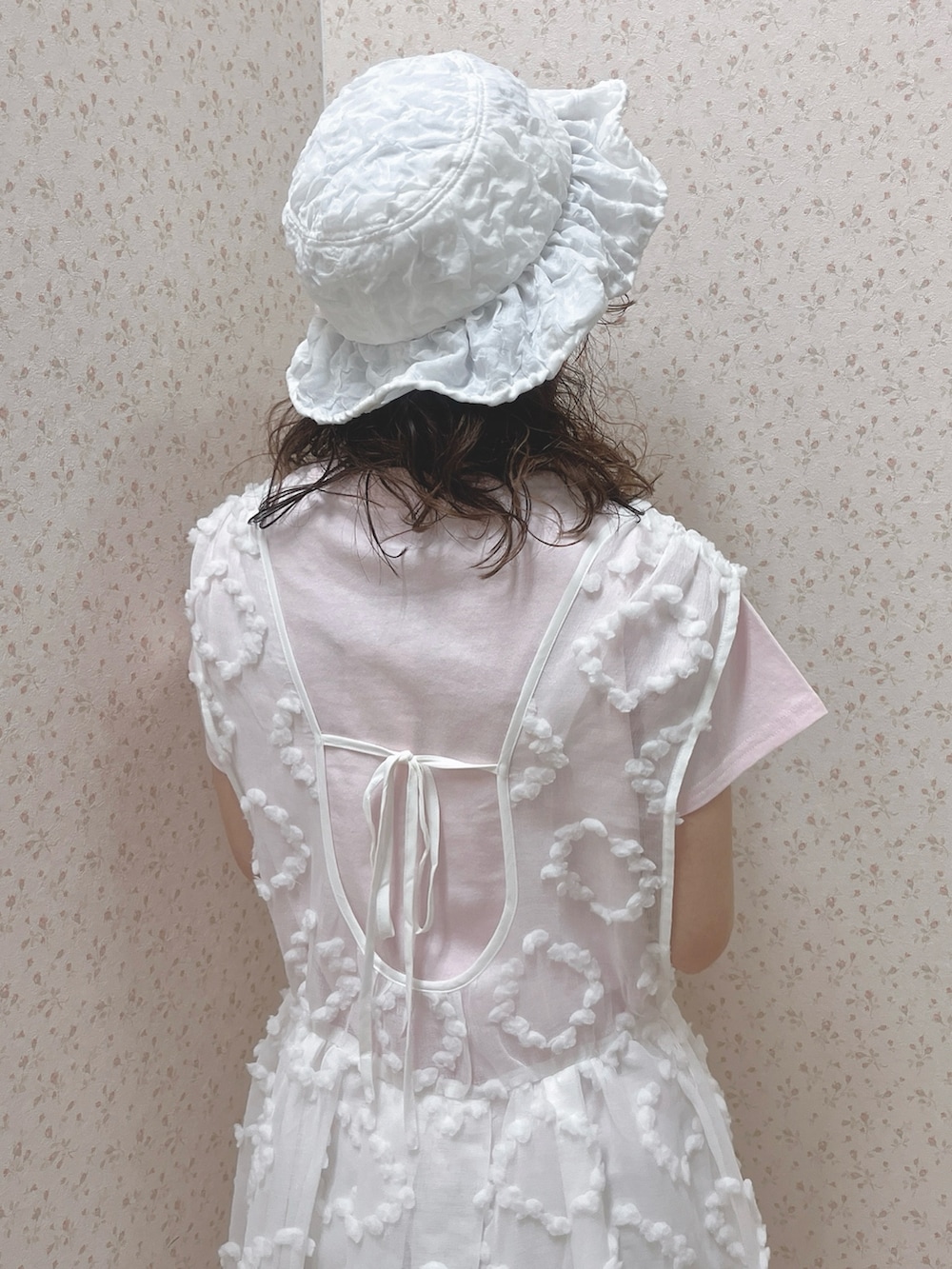 ピンク系のTシャツ/カットソー、ホワイト系のジャンパースカート、ホワイト系のスニーカーを着用したレディースの夏コーディネートの8枚目の写真