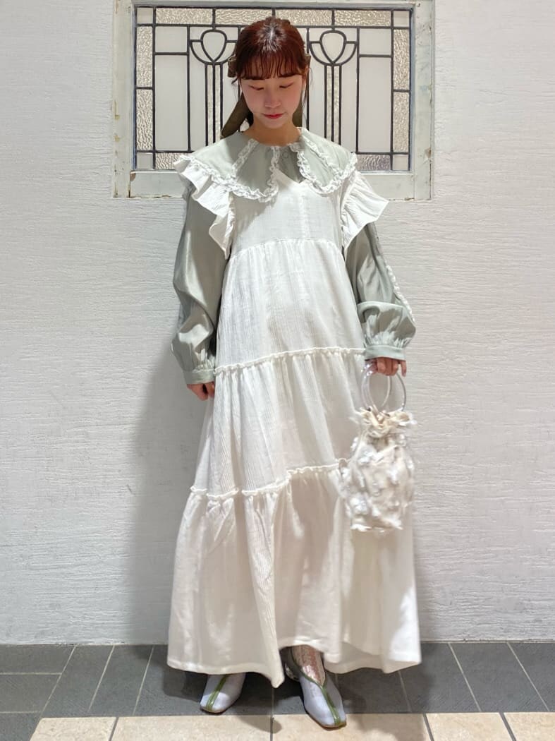 グリーン系のシャツ/ブラウス、ブルー系のパンプス、ホワイト系のワンピースを着用したレディースの冬コーディネートの2枚目の写真