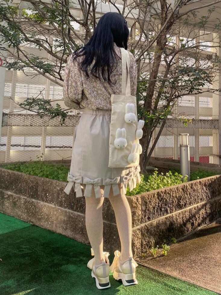 イエロー系のシャツ/ブラウス、ベージュ系のスカート、ホワイト系のスニーカーを着用したレディースの冬コーディネートの4枚目の写真