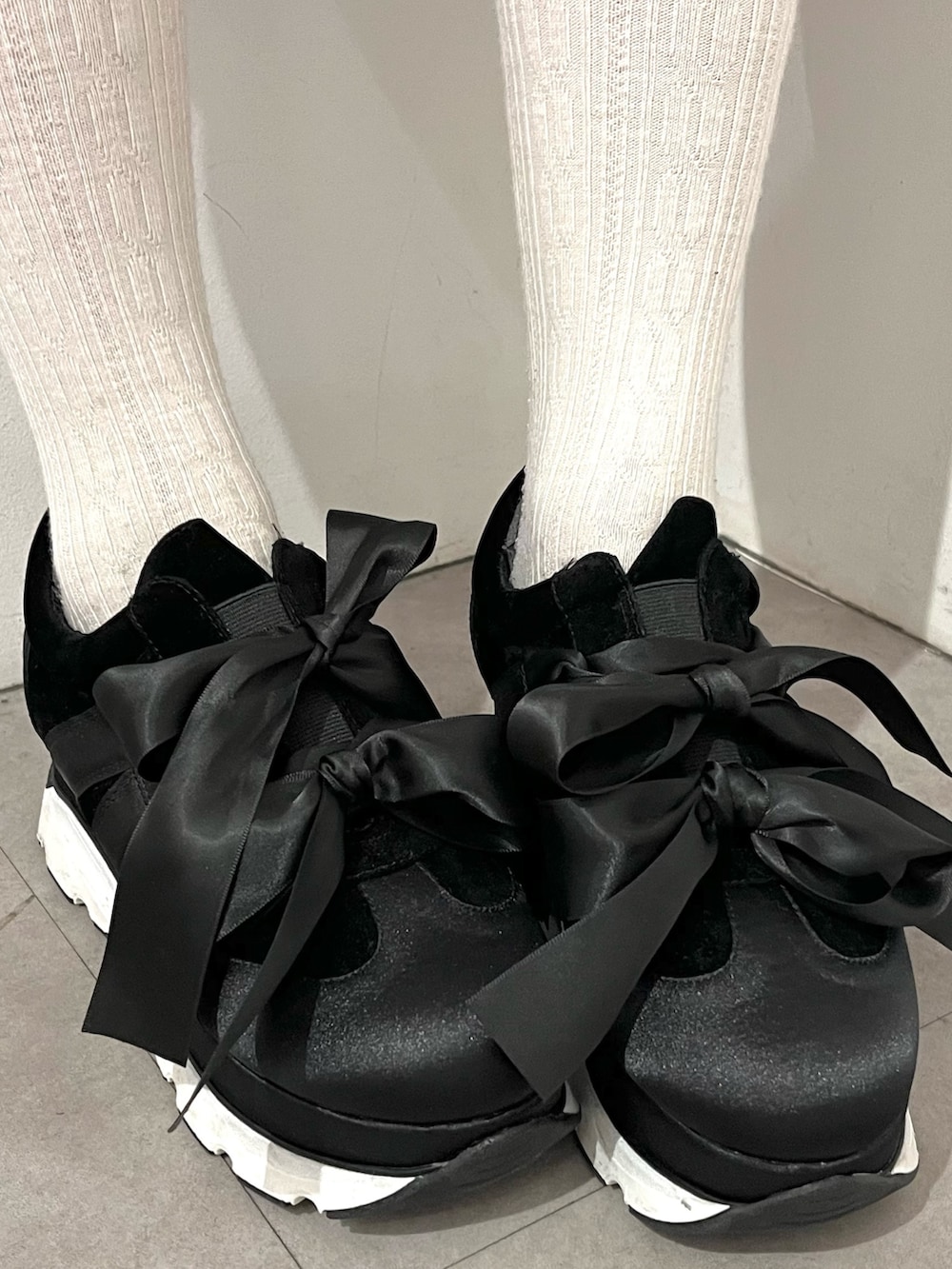 ブラック系のワンピース、ブラック系のスニーカーを着用したレディースの冬コーディネートの4枚目の写真