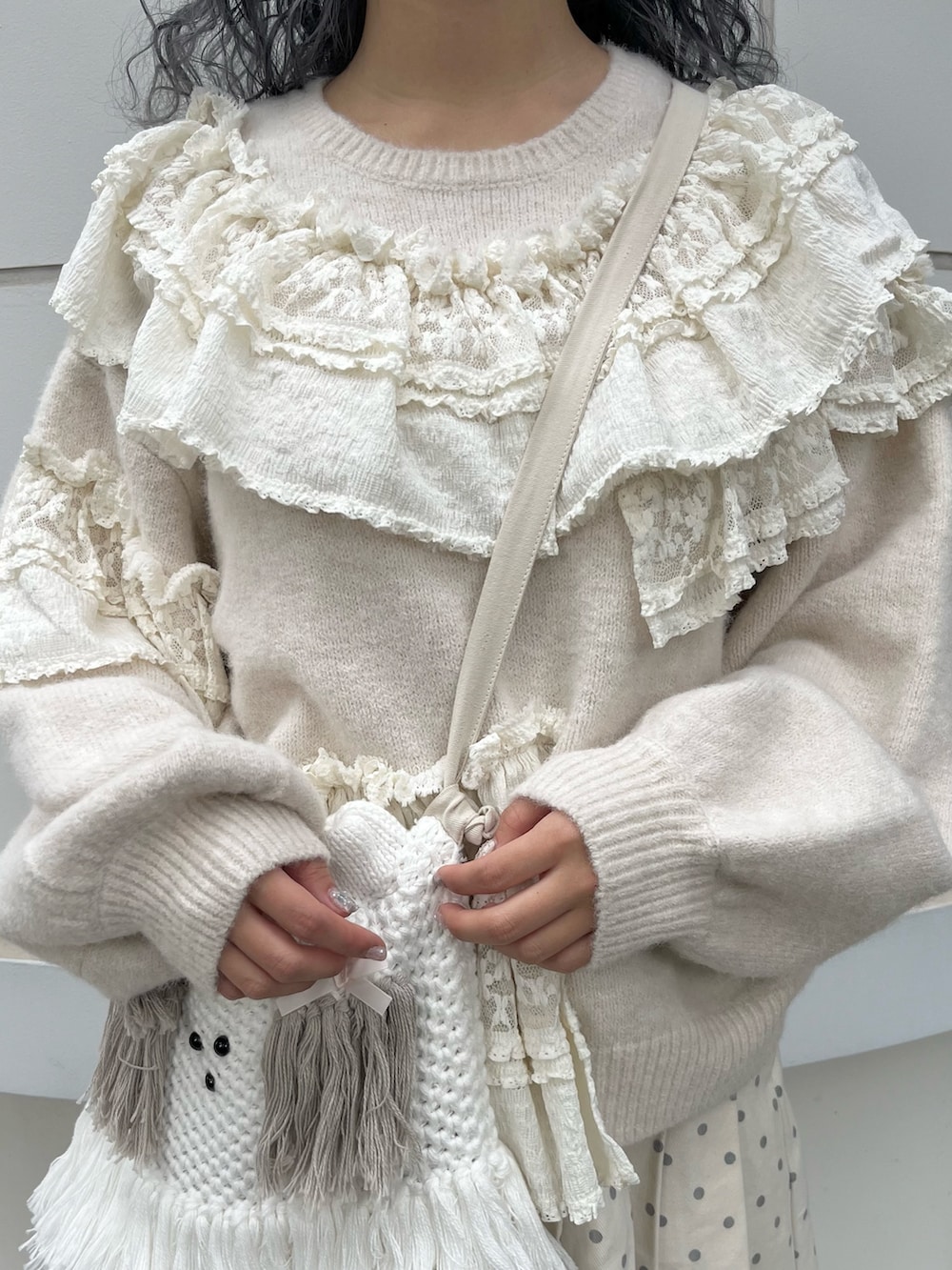 ホワイト系のニット/セーター、ホワイト系のスカート、ベージュ系のショルダーバッグを着用したレディースの秋コーディネートの6枚目の写真