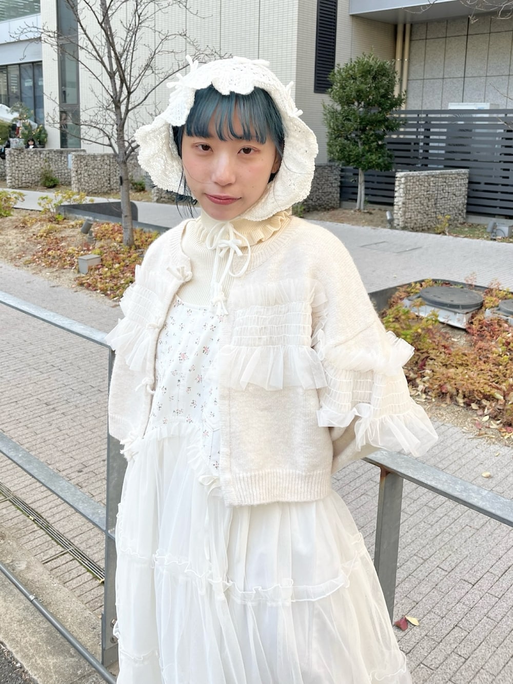 ホワイト系のニット/セーター、ホワイト系のカーディガン/ボレロ、ホワイト系のワンピースを着用したレディースの冬コーディネートの6枚目の写真