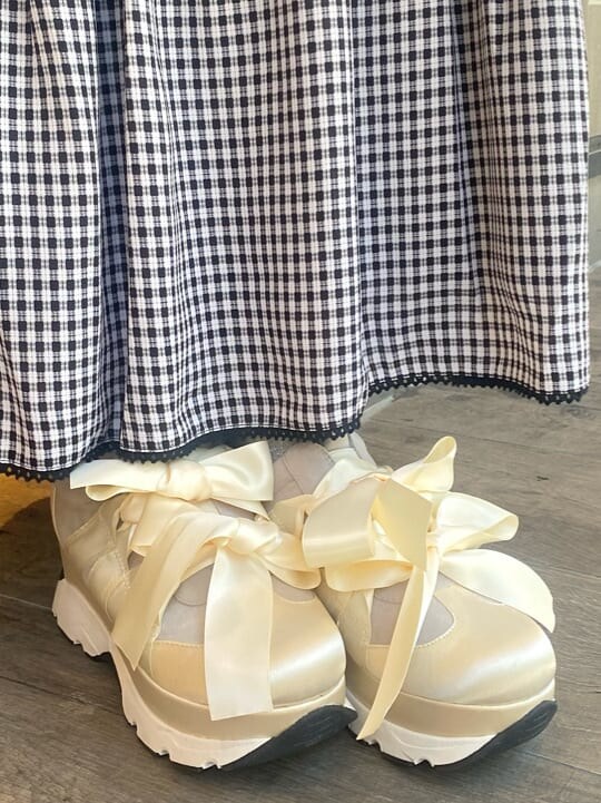 ホワイト系のスニーカー、ブラック系のスカート、ホワイト系のシャツ/ブラウスを着用したレディースの夏コーディネートの5枚目の写真