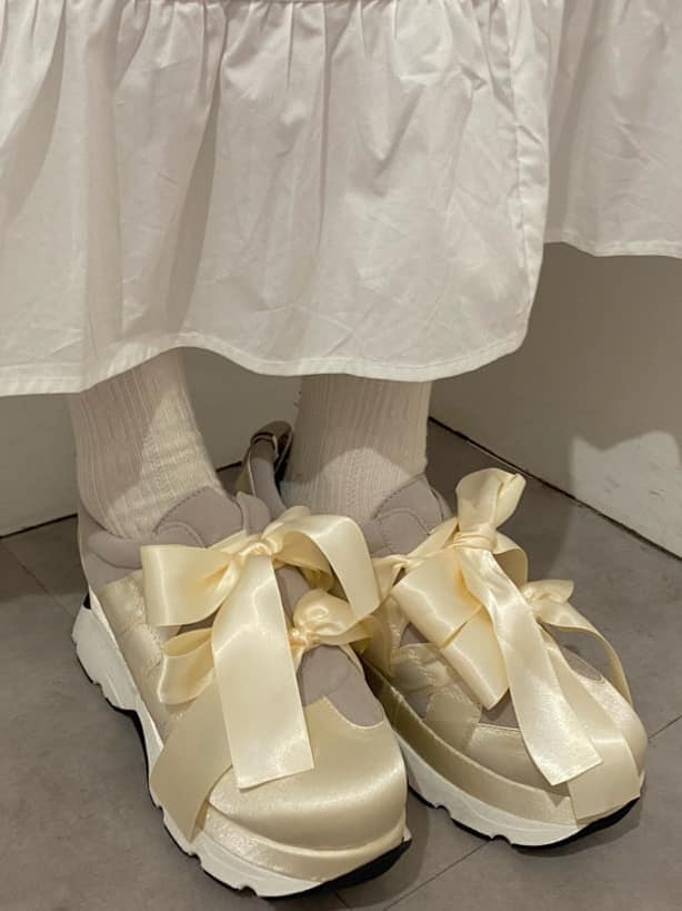 ホワイト系のスニーカー、ホワイト系のワンピース、ブルー系のカーディガン/ボレロを着用したレディースの冬コーディネートの6枚目の写真