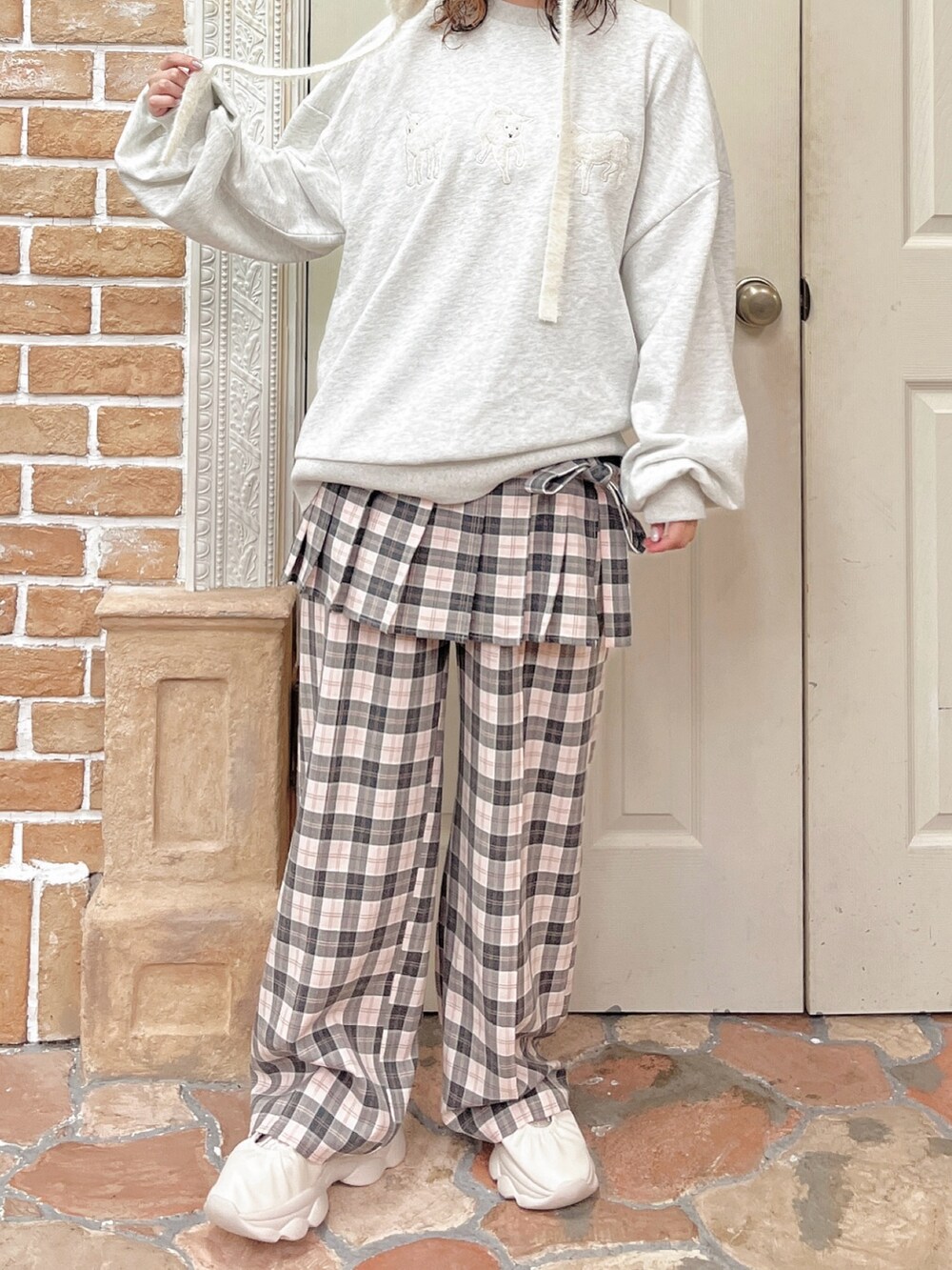 ピンク系のスラックス、グレー系のスウェット、ホワイト系のスニーカーを着用したレディースの夏コーディネートの4枚目の写真