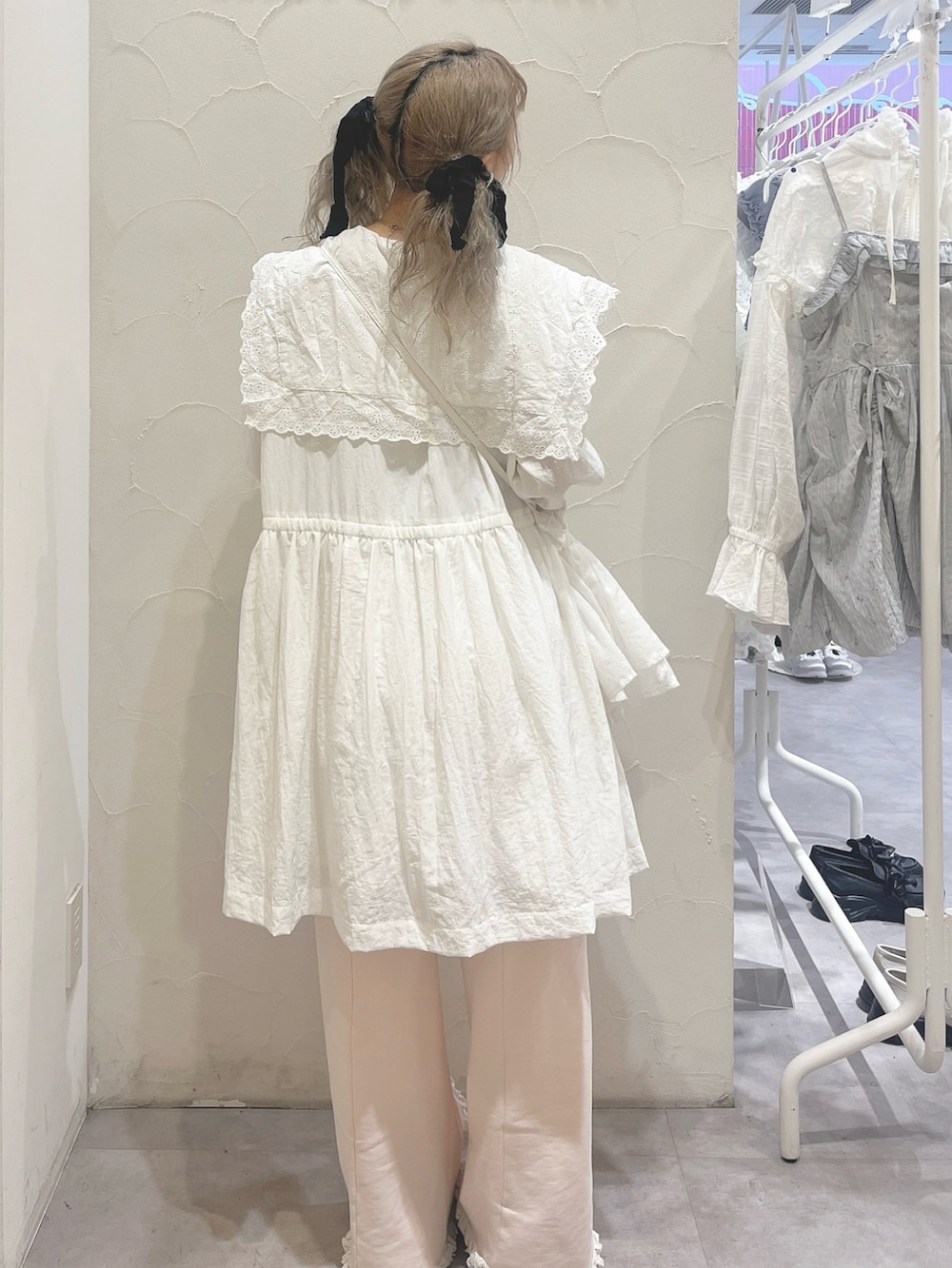 ホワイト系のワンピース、ピンク系のスウェットパンツ、ホワイト系のショルダーバッグを着用したレディースの春コーディネートの4枚目の写真