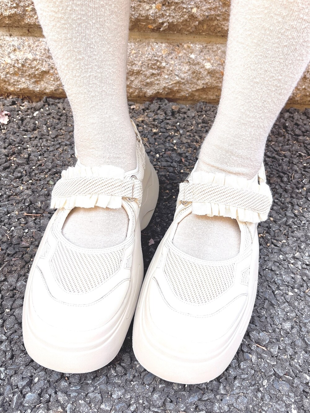 ホワイト系のニット/セーター、ホワイト系のショルダーバッグ、ピンク系のスカートを着用したレディースの秋コーディネートの8枚目の写真