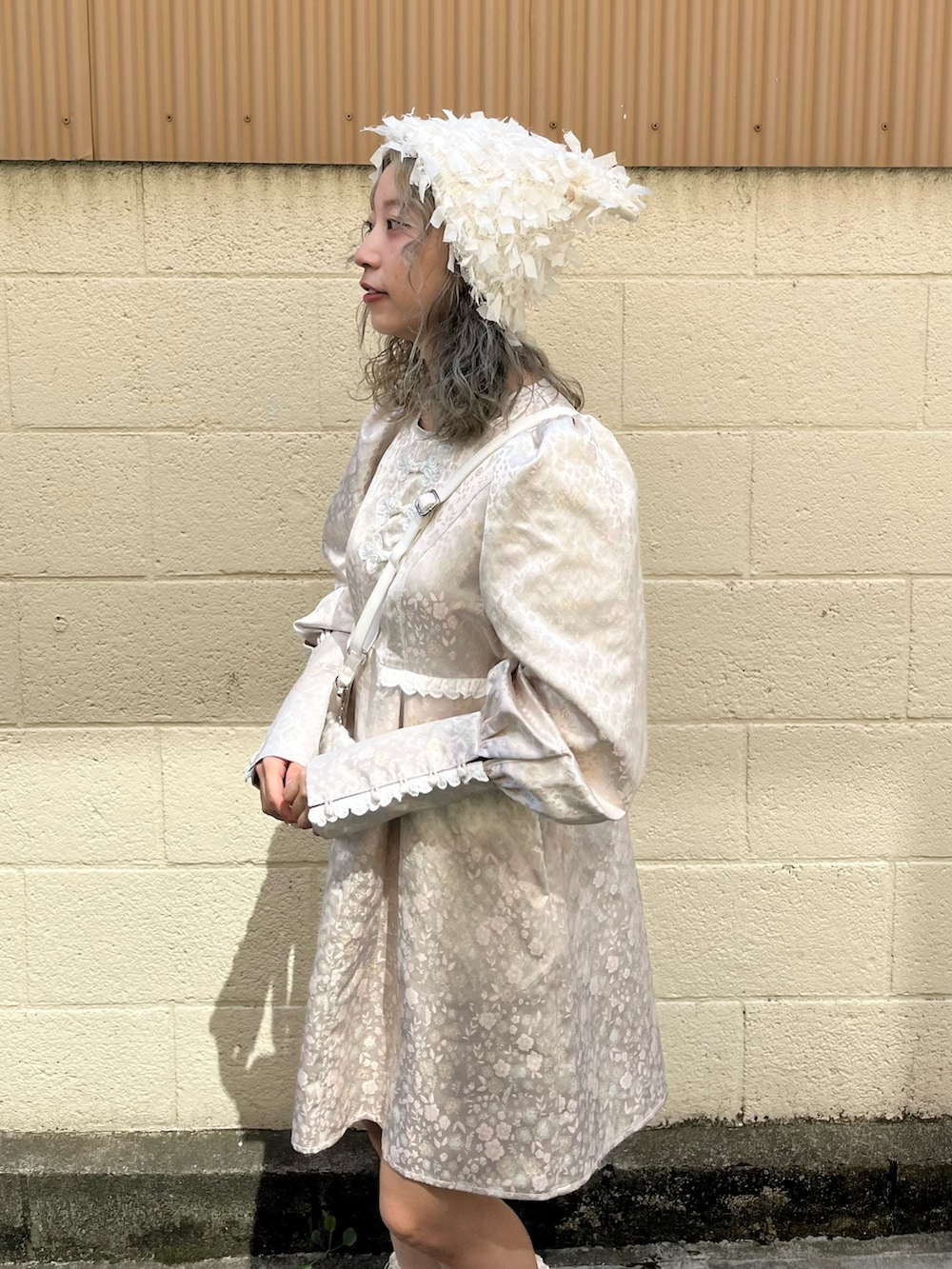 ピンク系のワンピース、ホワイト系のショルダーバッグ、ホワイト系のスニーカーを着用したレディースの秋コーディネートの5枚目の写真