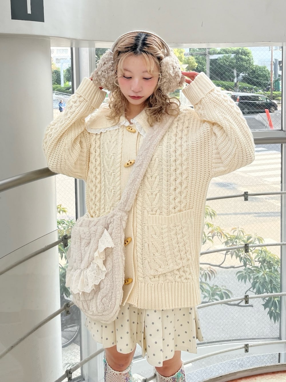 ホワイト系のカーディガン/ボレロ、ホワイト系のスカート、ベージュ系のショルダーバッグを着用したレディースの冬コーディネートの5枚目の写真