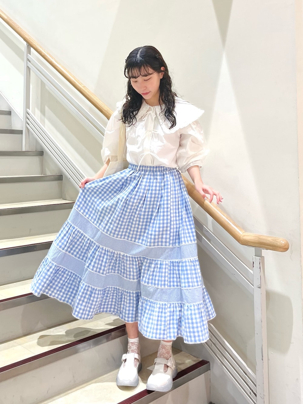 ホワイト系のシャツ/ブラウス、ブルー系のスカート、ホワイト系のトートバッグを着用したレディースの春コーディネートの2枚目の写真