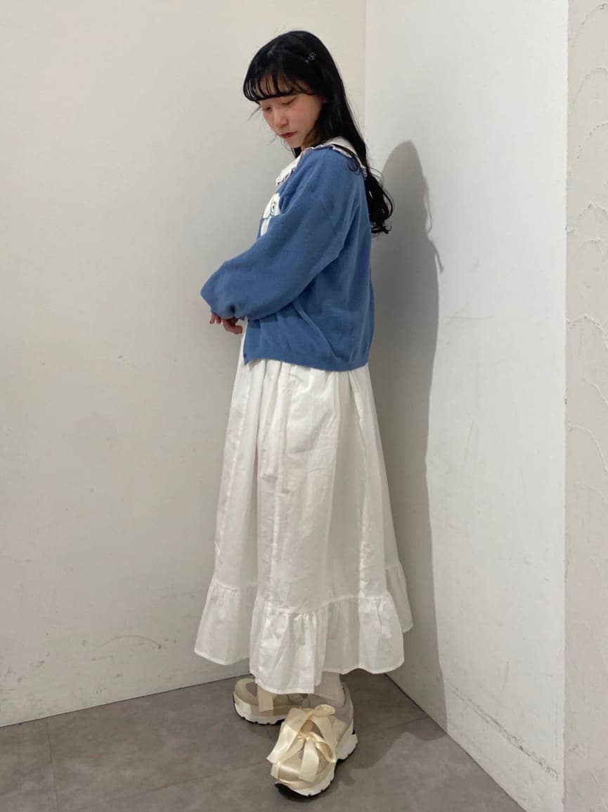 ホワイト系のスニーカー、ホワイト系のワンピース、ブルー系のカーディガン/ボレロを着用したレディースの冬コーディネートの2枚目の写真