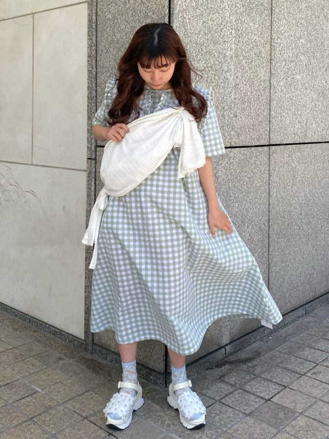 ホワイト系のサンダル、ホワイト系のショルダーバッグ、グリーン系のワンピースを着用したレディースの春コーディネートの2枚目の写真