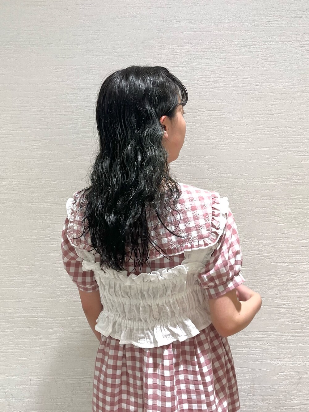 ピンク系のワンピース、ホワイト系のサンダル、ホワイト系のベストを着用したレディースの夏コーディネートの5枚目の写真