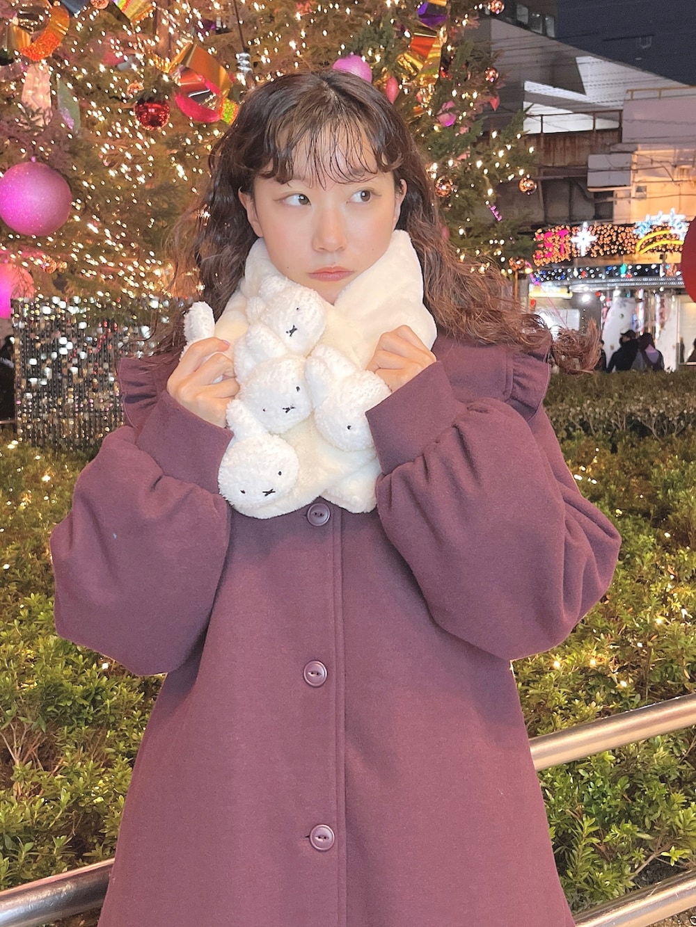 レッド系のチェスターコート、ホワイト系のニット/セーター、ホワイト系のスウェットを着用したレディースの冬コーディネートの5枚目の写真