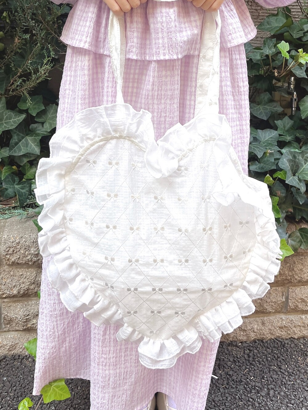 パープル系のワンピース、ホワイト系のトートバッグ、ホワイト系のバレエシューズを着用したレディースの冬コーディネートの8枚目の写真