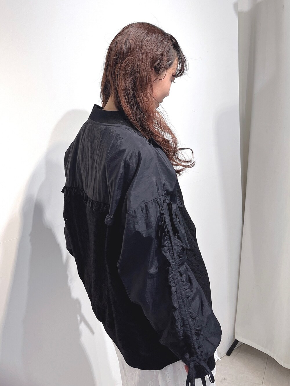 ブラック系のブルゾン、ホワイト系のTシャツ/カットソー、ホワイト系のスカートを着用したレディースの冬コーディネートの5枚目の写真