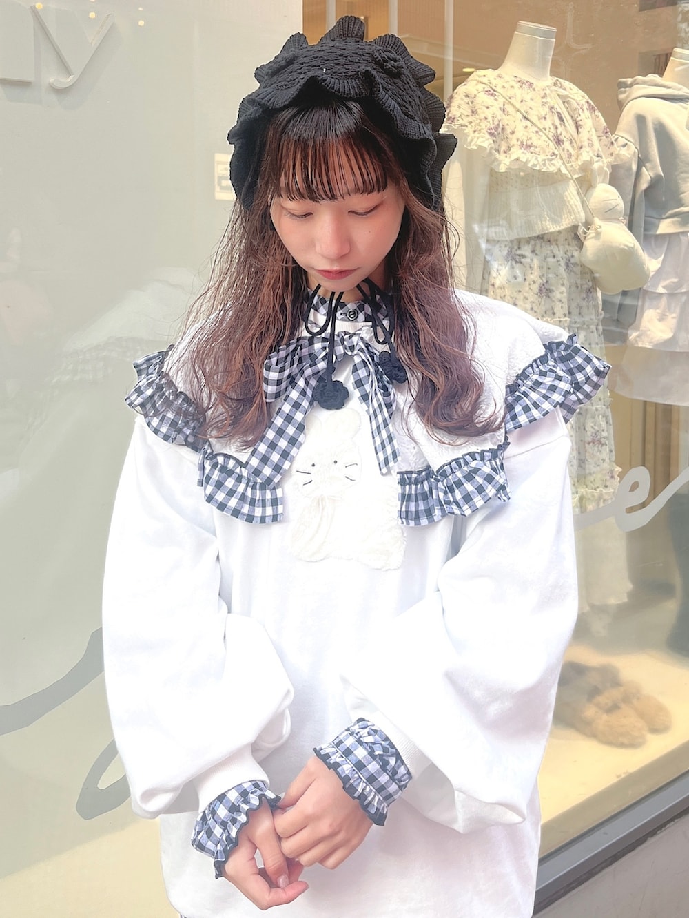 ホワイト系のスウェット、ブラック系のワンピース、ブラック系のスニーカーを着用したレディースの冬コーディネートの5枚目の写真