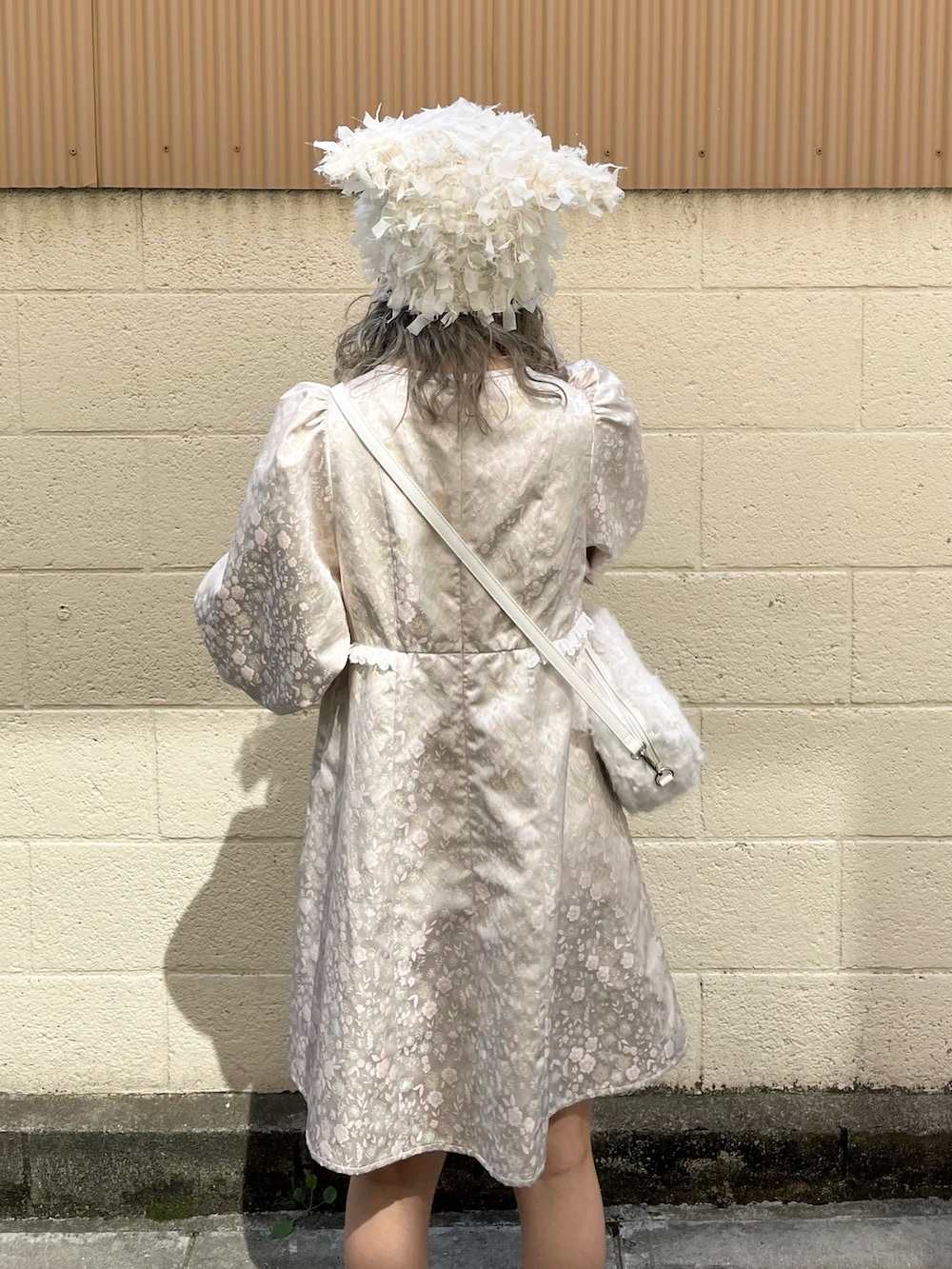 ピンク系のワンピース、ホワイト系のショルダーバッグ、ホワイト系のスニーカーを着用したレディースの秋コーディネートの6枚目の写真