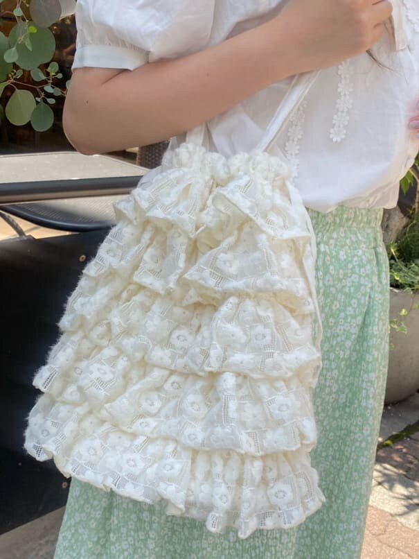 ホワイト系のサンダル、ホワイト系のトートバッグ、ホワイト系のシャツ/ブラウスを着用したレディースの春コーディネートの6枚目の写真