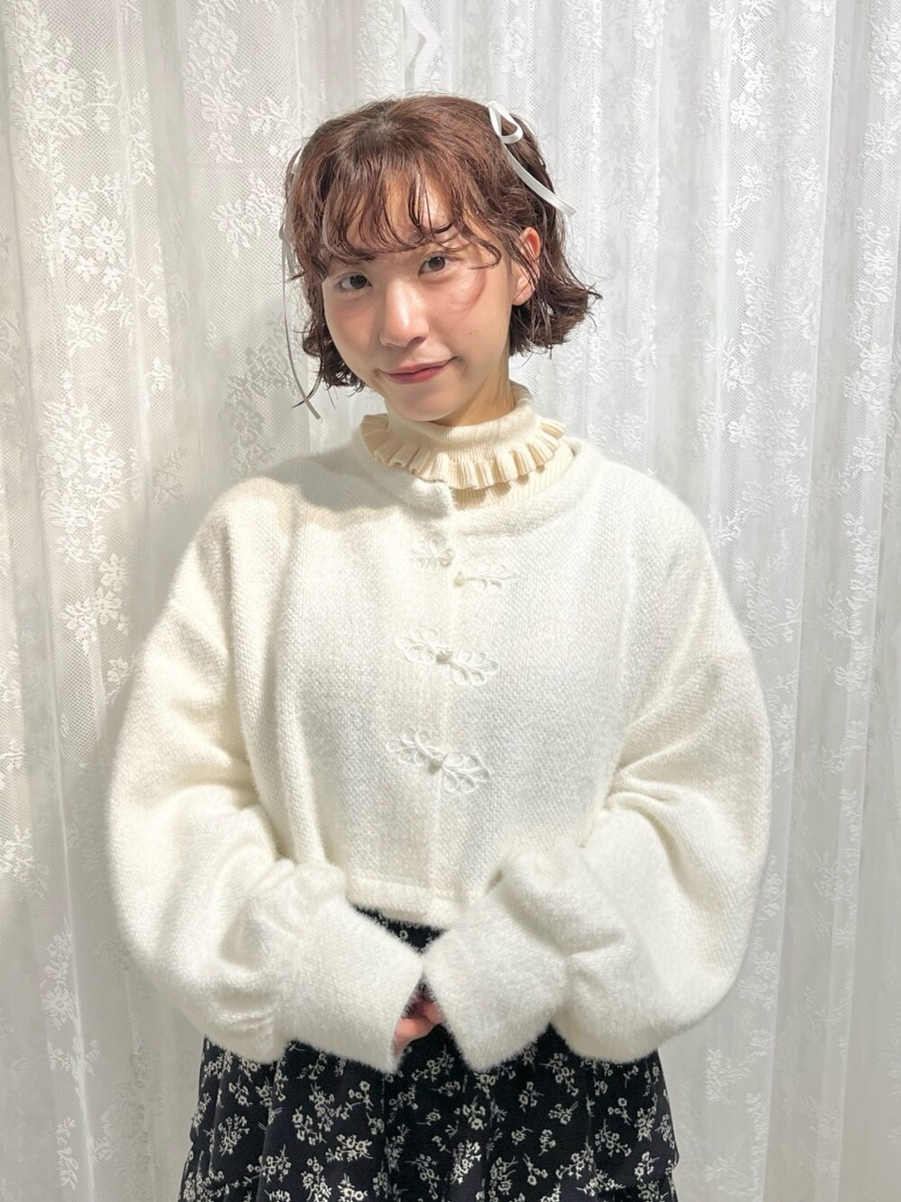 ホワイト系のカーディガン/ボレロ、ホワイト系のニット/セーター、ブラック系のワンピースを着用したレディースの秋コーディネートの6枚目の写真