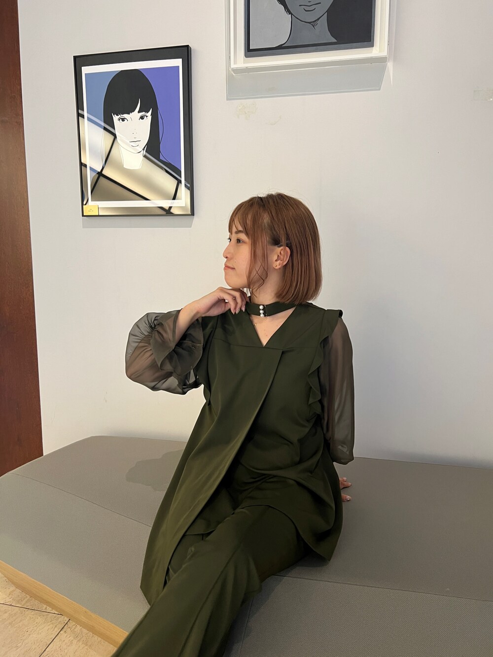 グリーン系のパンツドレス、ブラック系のパンプスを着用したレディースの秋コーディネートの2枚目の写真