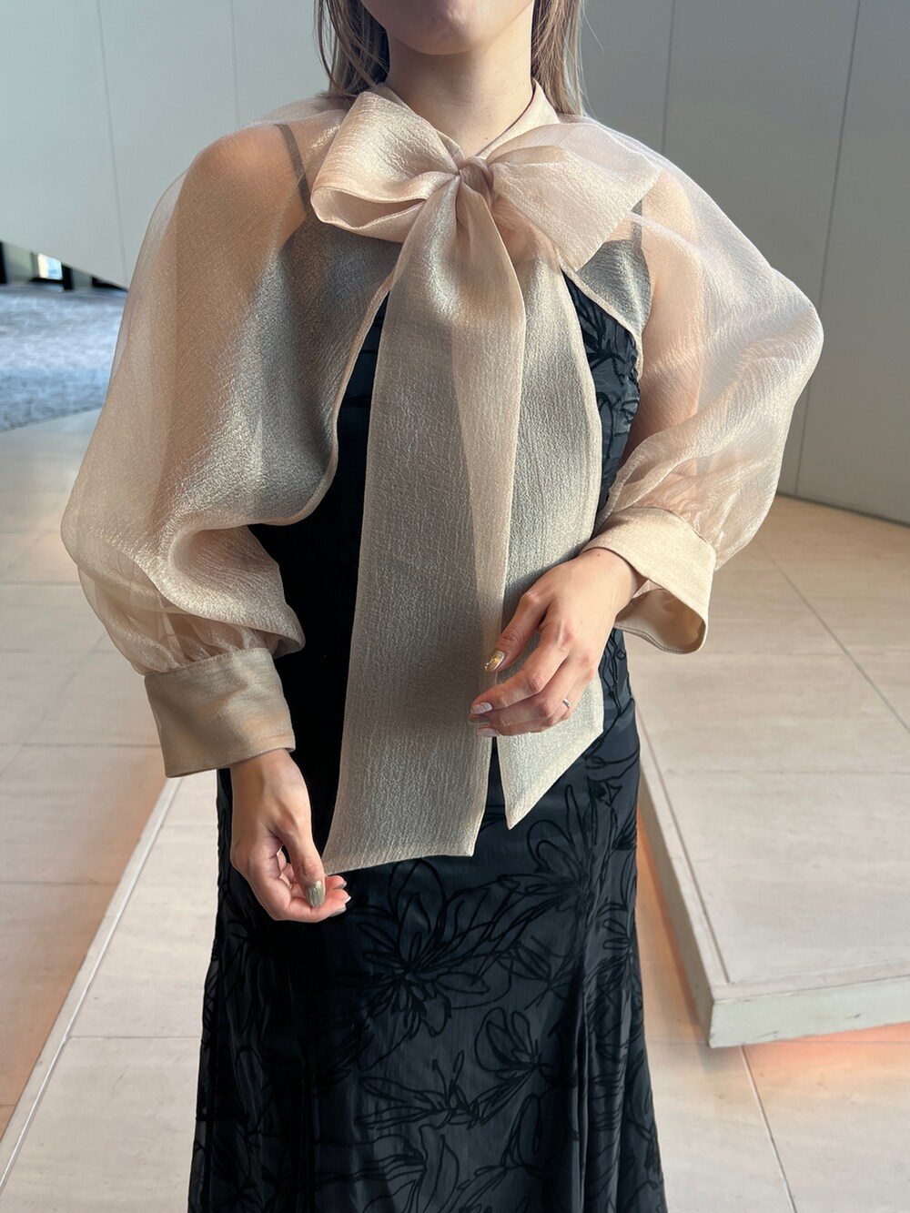 ブラック系のドレス、ホワイト系のノーカラージャケット、ベージュ系のシューズを着用したレディースの冬コーディネートの5枚目の写真