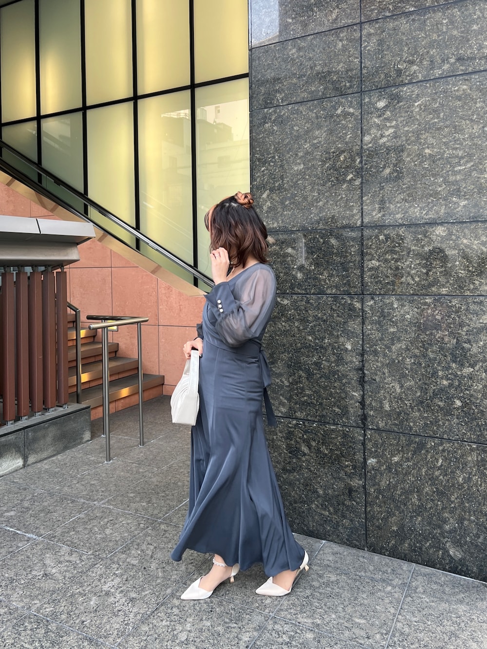 グリーン系のドレス、ベージュ系のハンドバッグ、ベージュ系のシューズを着用したレディースの春コーディネートの2枚目の写真