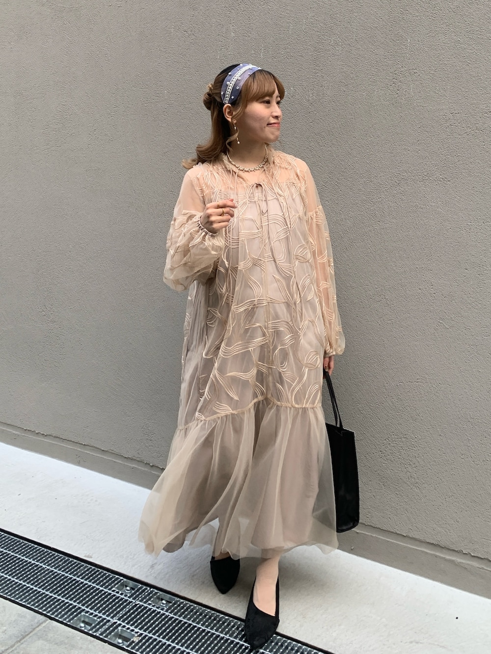 ピンク系のドレス、ホワイト系のネックレスを着用したレディースの春コーディネートの2枚目の写真