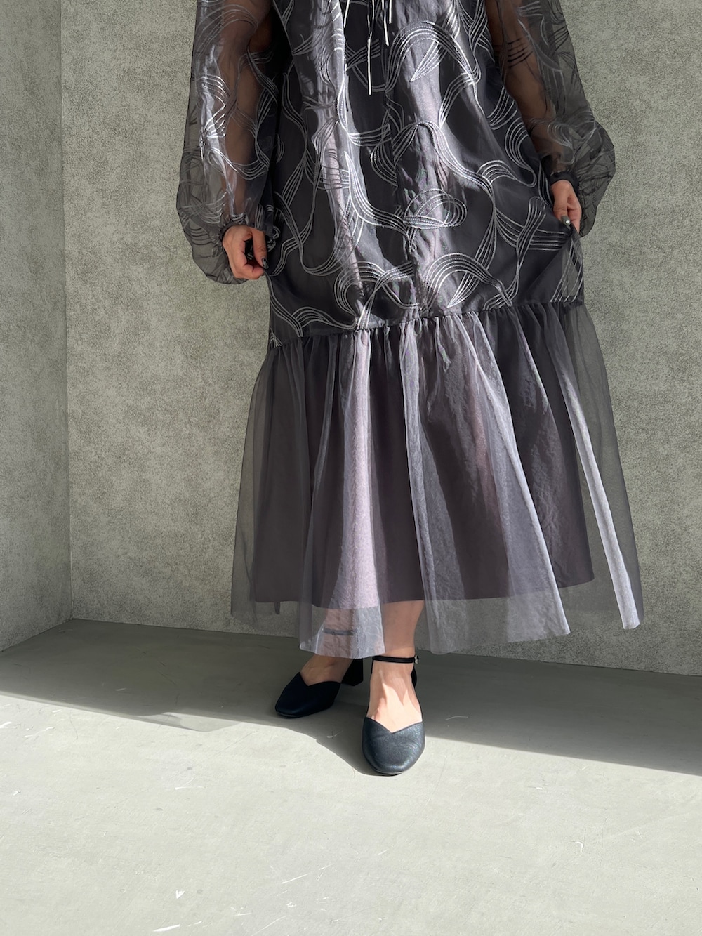 グレー系のドレス、ブラック系のパンプスを着用したレディースの夏コーディネートの4枚目の写真