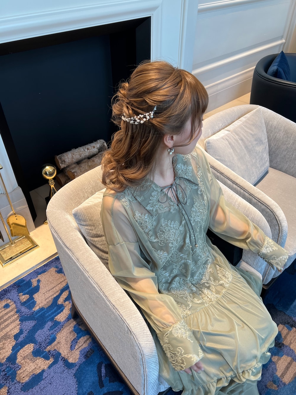 グリーン系のドレス、ブラック系のハンドバッグ、シルバー系のヘアピンを着用したレディースの春コーディネートの5枚目の写真