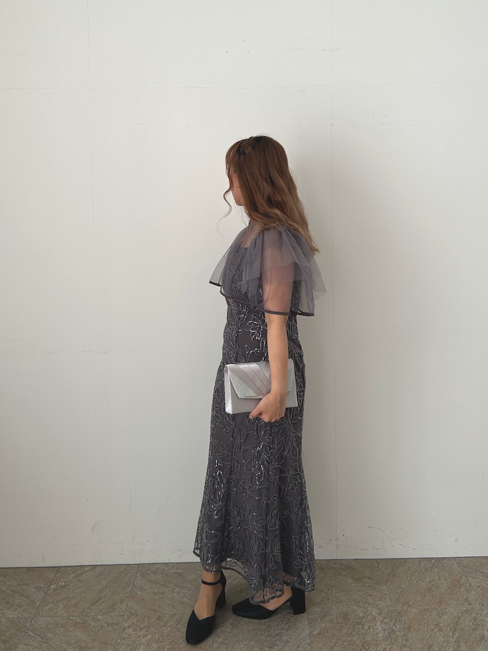 グレー系のドレス、ブラック系のパンプスを着用したレディースの冬コーディネートの2枚目の写真