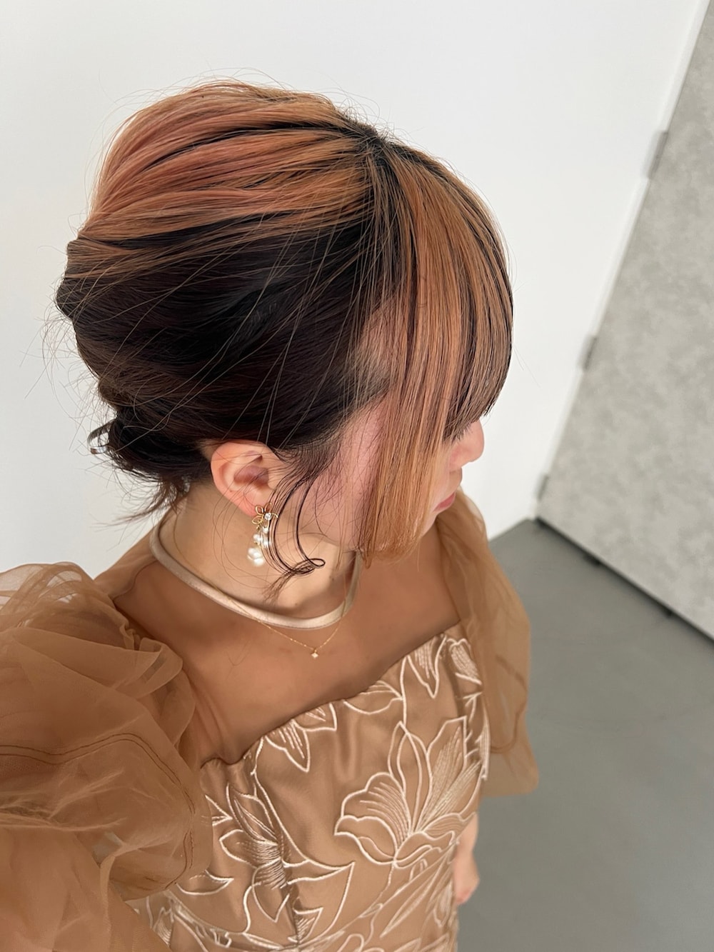 オレンジ系のドレス、ブラック系のパンプス、ブラック系のショルダーバッグを着用したレディースの春コーディネートの8枚目の写真