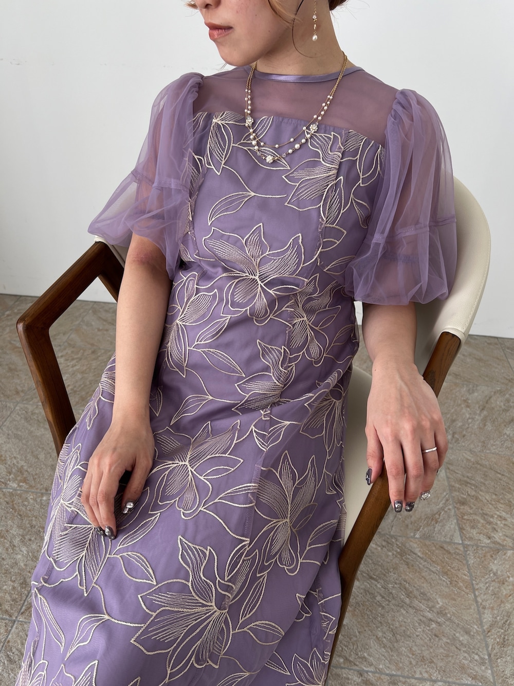 ゴールド系のバッグ、ベージュ系のシューズ、パープル系のドレスを着用したレディースの夏コーディネートの8枚目の写真