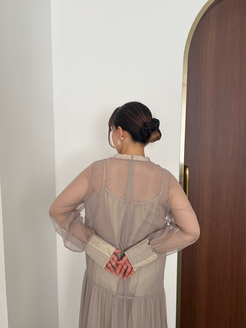 ベージュ系のドレス、ゴールド系のハンドバッグ、ベージュ系のシューズを着用したレディースの秋コーディネートの4枚目の写真