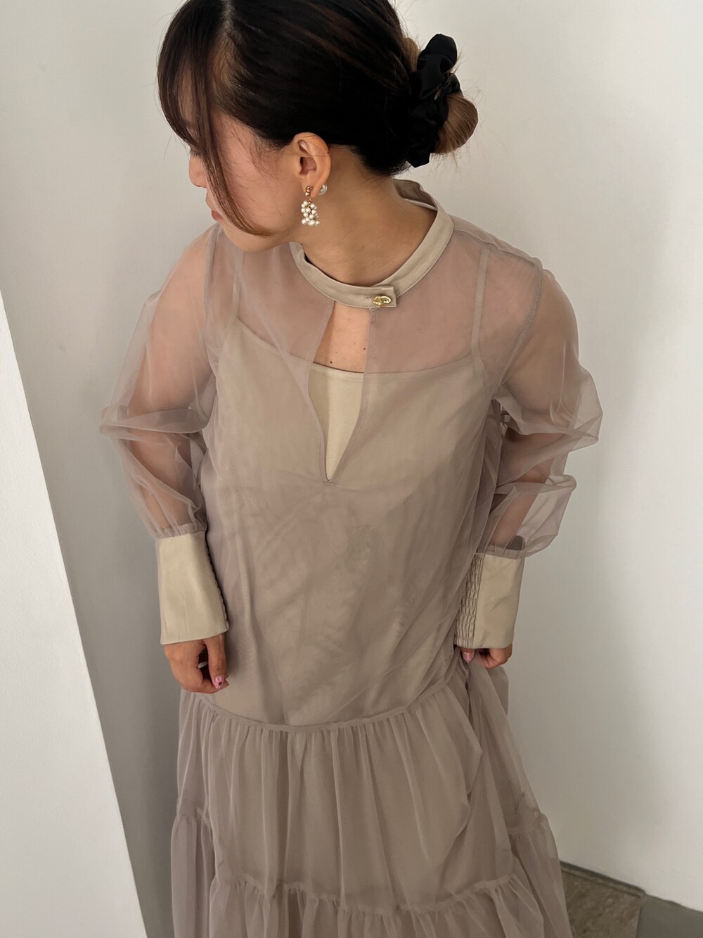 ベージュ系のドレス、ゴールド系のハンドバッグ、ベージュ系のシューズを着用したレディースの秋コーディネートの3枚目の写真