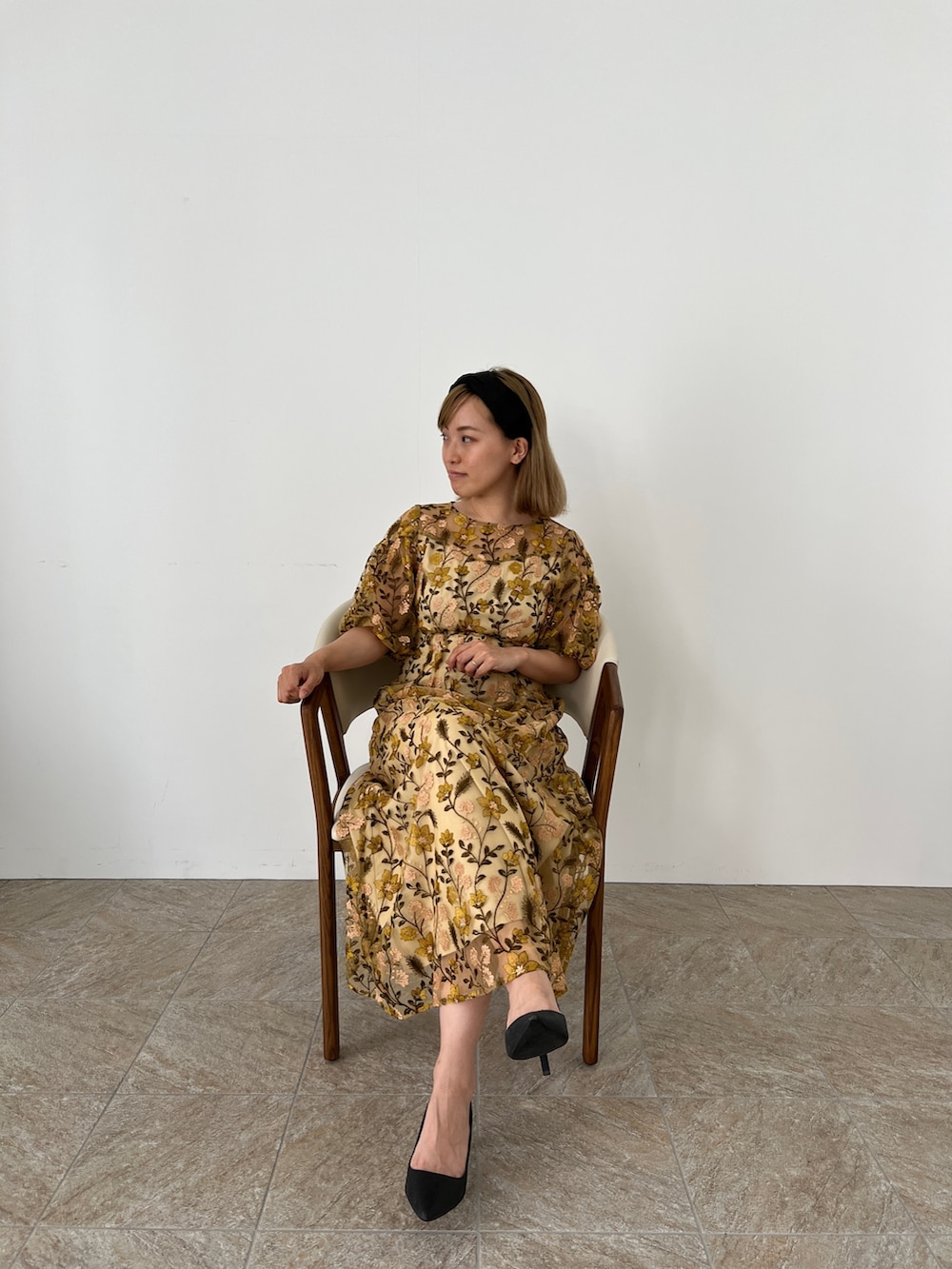 イエロー系のドレス、ブラック系のパンプス、ブラック系のカチューシャを着用したレディースの夏コーディネートの5枚目の写真