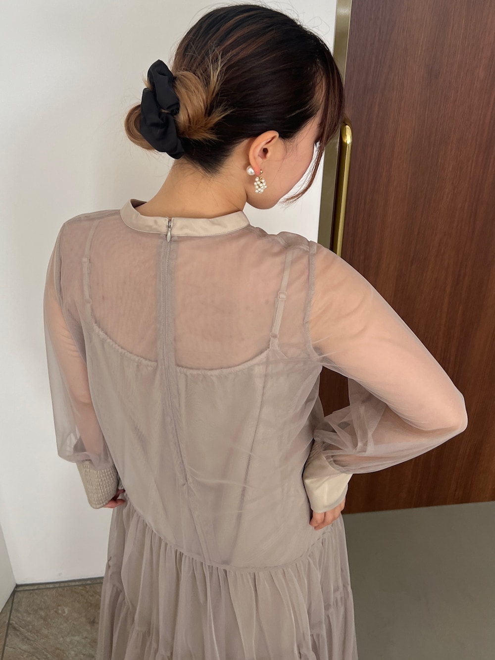 ベージュ系のドレス、ゴールド系のハンドバッグ、ベージュ系のシューズを着用したレディースの秋コーディネートの5枚目の写真