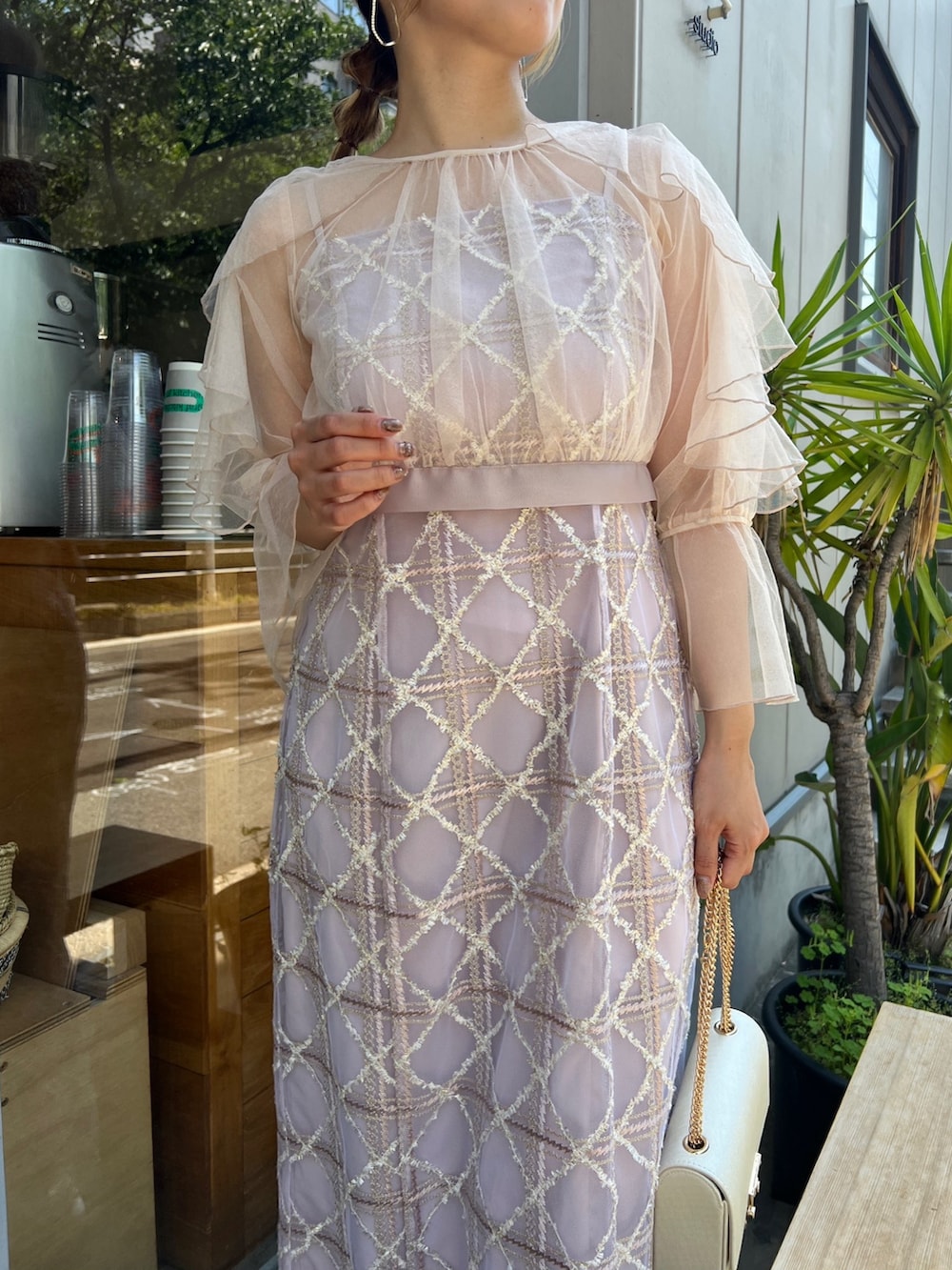 ベージュ系のクラッチバッグ、ベージュ系のパンプス、ピンク系のドレスを着用したレディースの夏コーディネートの2枚目の写真