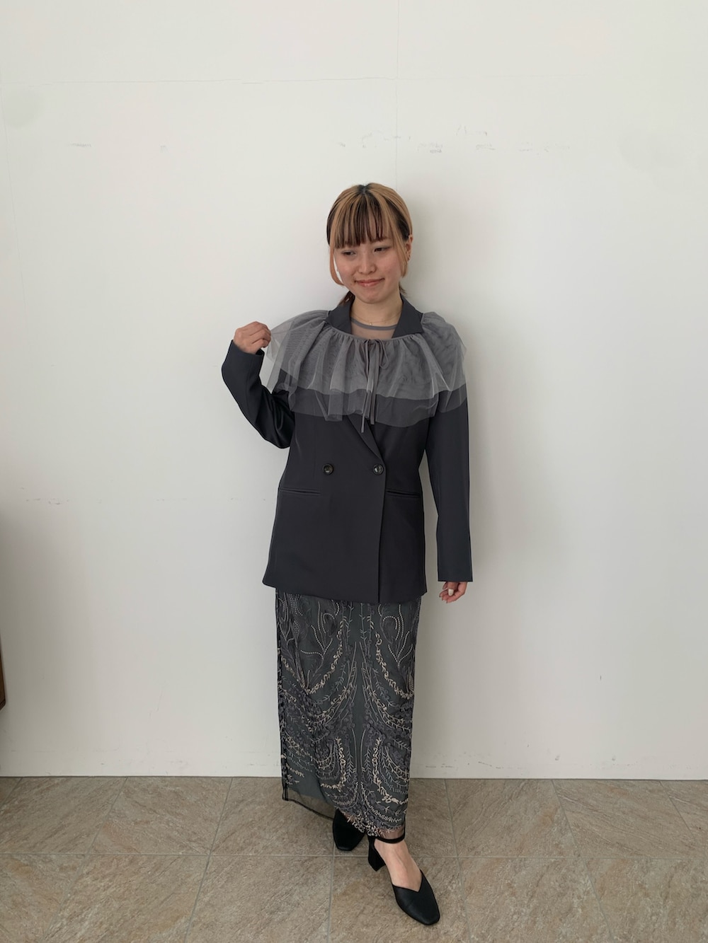 グレー系のドレス、グレー系のジャケット/アウター、ブラック系のパンプスを着用したレディースの春コーディネートの7枚目の写真