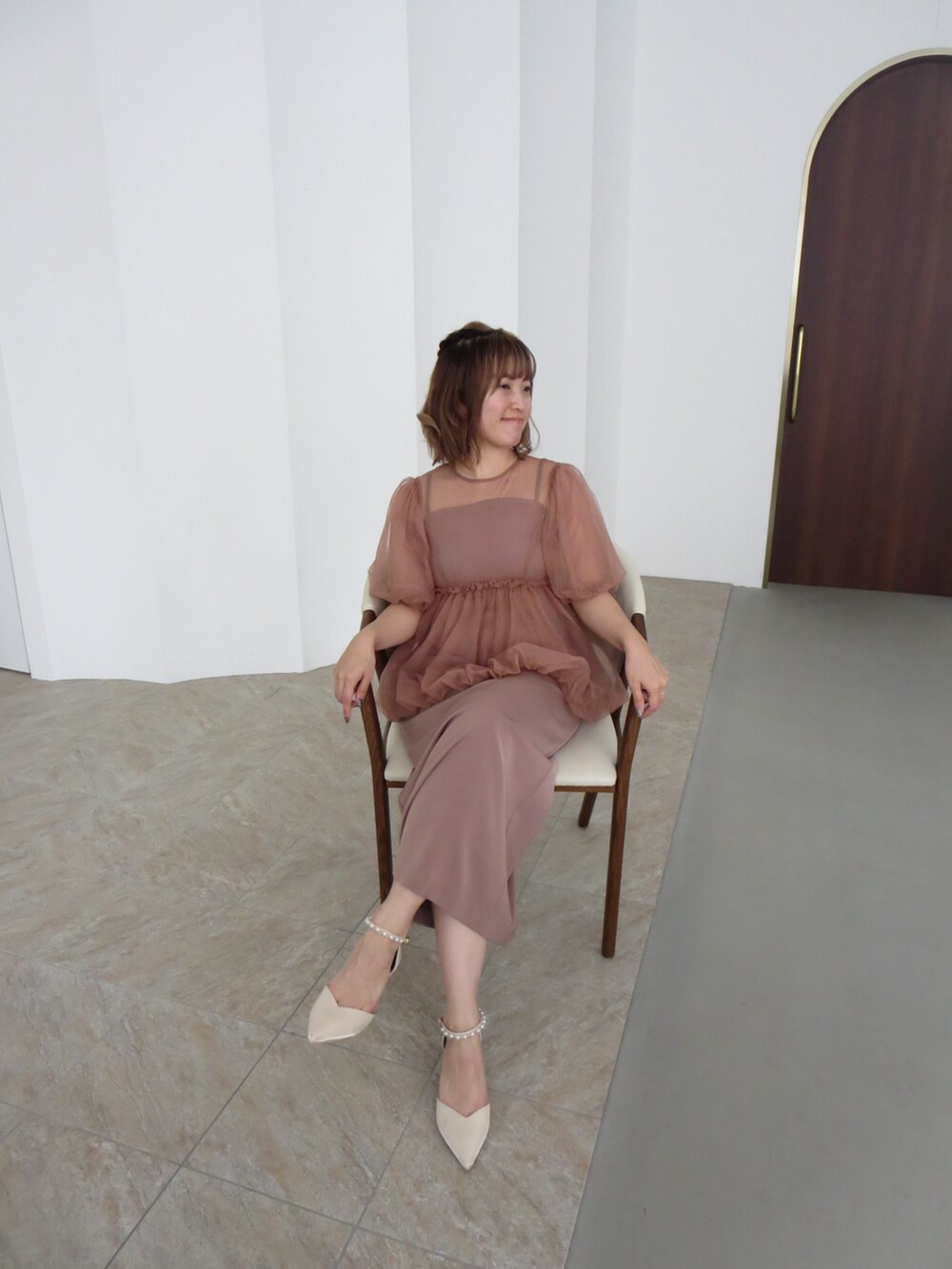 オレンジ系のドレスを着用したレディースの冬コーディネートの5枚目の写真