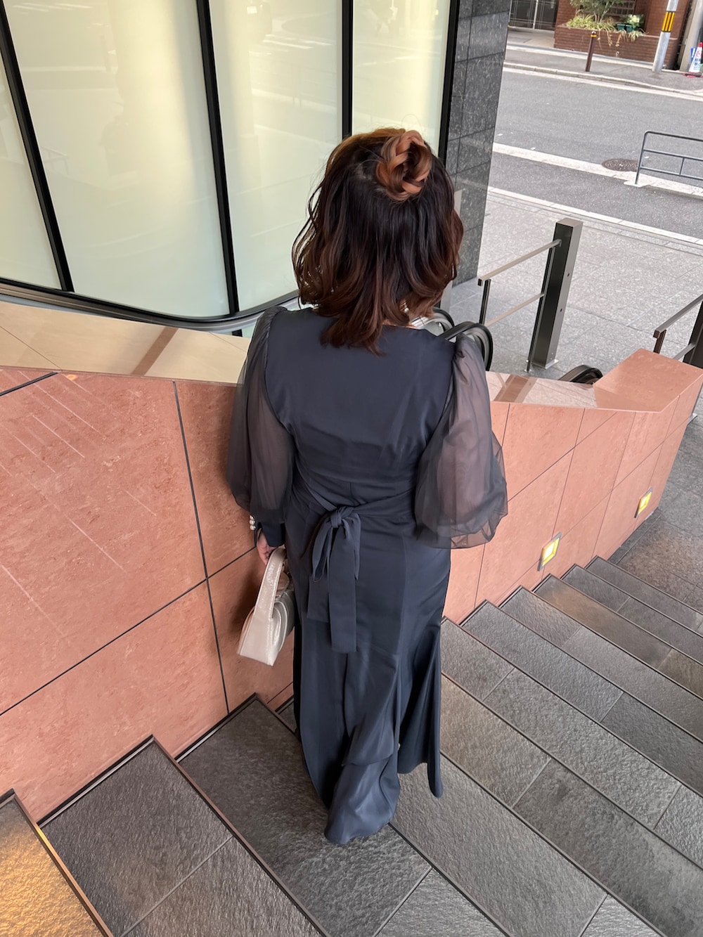 グリーン系のドレス、ベージュ系のハンドバッグ、ベージュ系のシューズを着用したレディースの春コーディネートの5枚目の写真