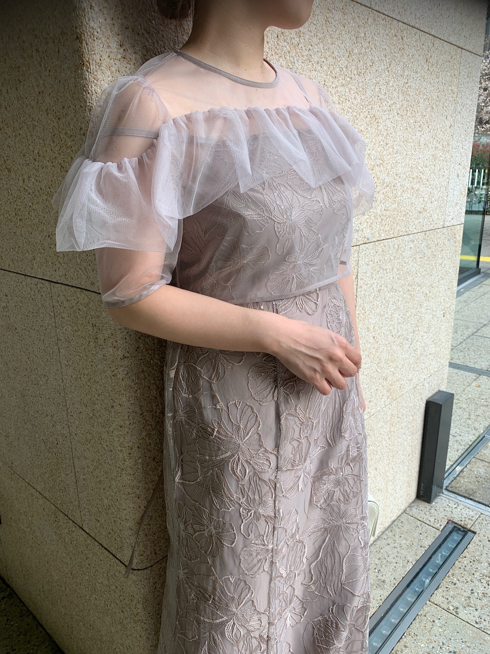 ベージュ系のドレス、ベージュ系のクラッチバッグ、ゴールド系のヘアピンを着用したレディースの春コーディネートの8枚目の写真