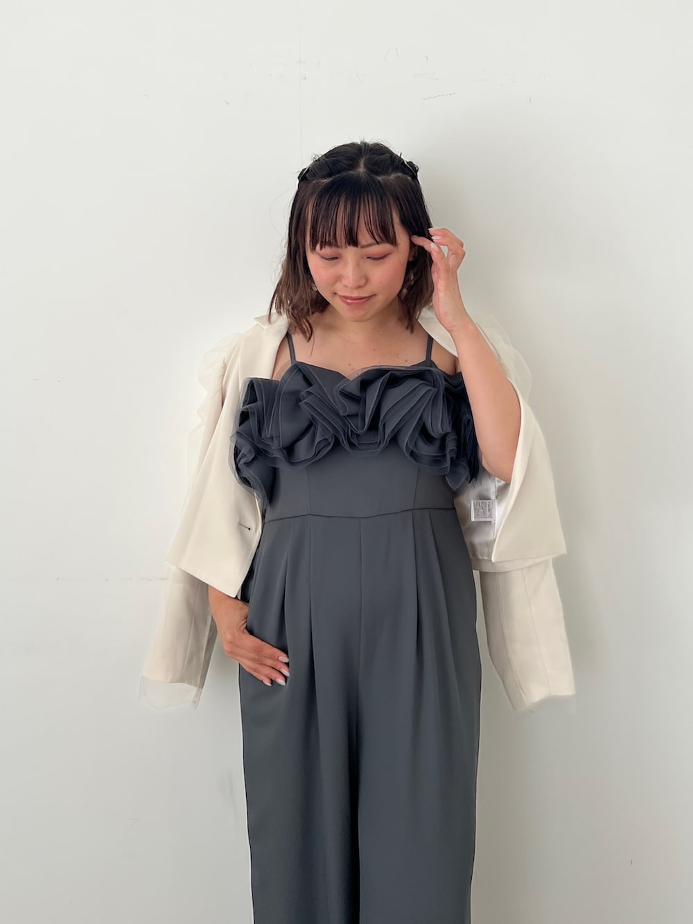 グレー系のパンツドレス、ベージュ系のパンプスを着用したレディースの秋コーディネートの4枚目の写真