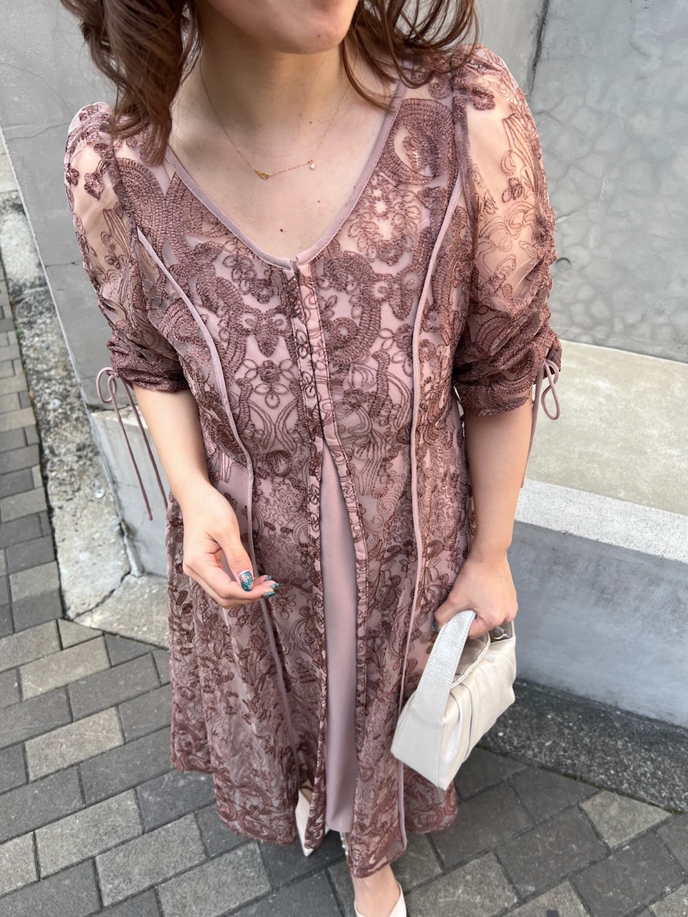 ピンク系のドレス、ベージュ系のハンドバッグ、ベージュ系のシューズを着用したレディースの春コーディネートの4枚目の写真