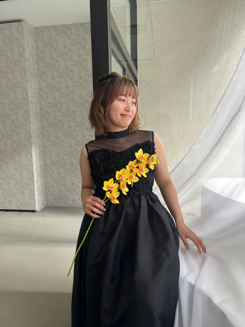 ブラック系のドレス、ブラック系のパンプスを着用したレディースの春コーディネートの5枚目の写真