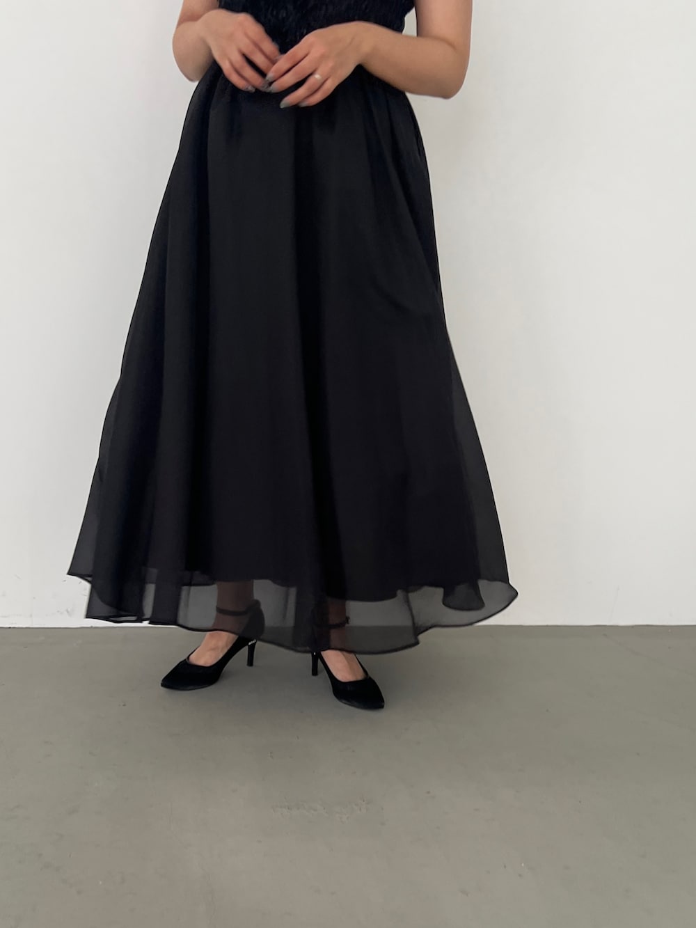 ブラック系のドレス、ブラック系のパンプスを着用したレディースの春コーディネートの3枚目の写真