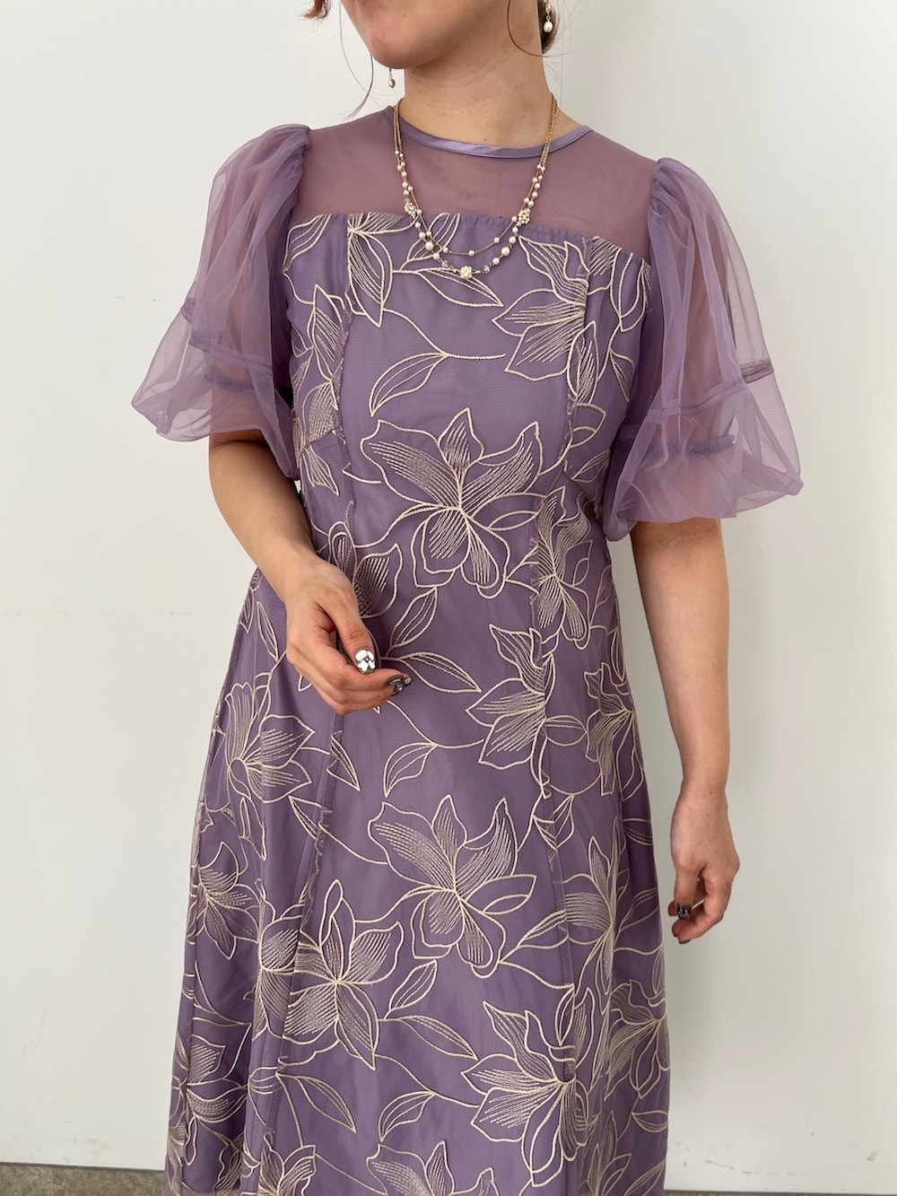 ゴールド系のバッグ、ベージュ系のシューズ、パープル系のドレスを着用したレディースの夏コーディネートの5枚目の写真