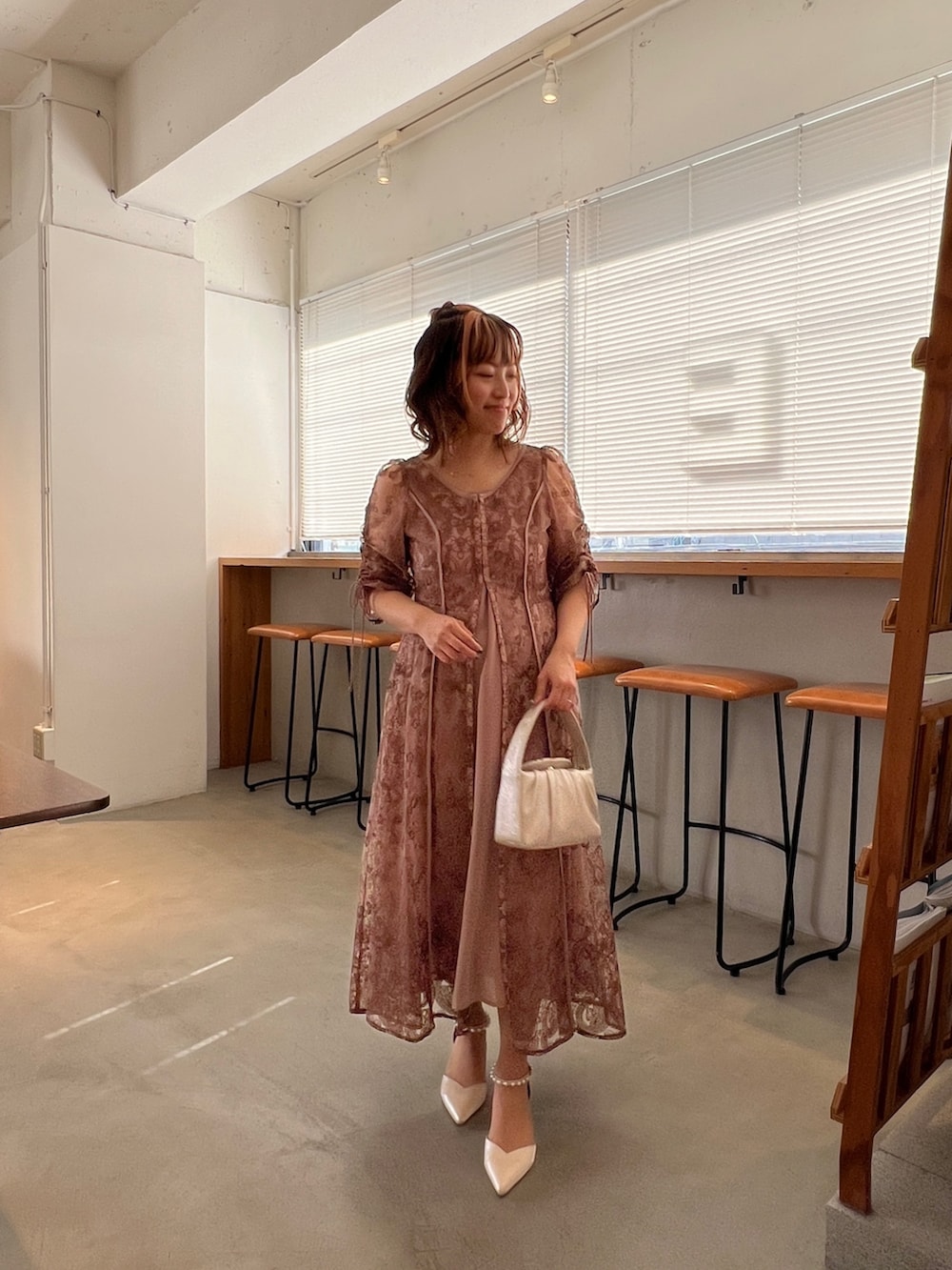 ピンク系のドレス、ベージュ系のハンドバッグ、ベージュ系のシューズを着用したレディースの春コーディネートの6枚目の写真