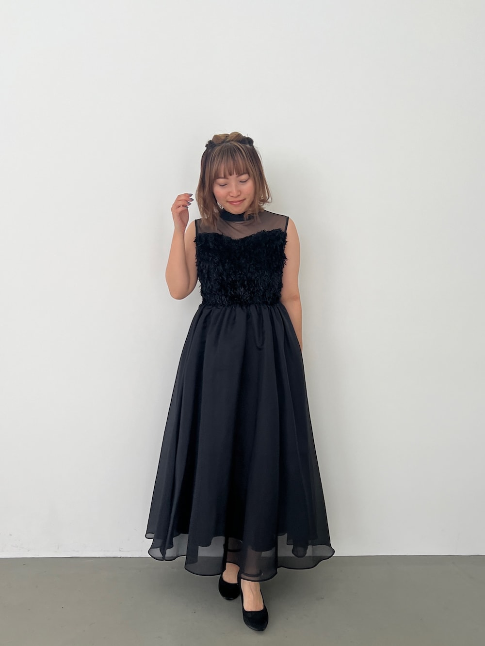 ブラック系のドレス、ブラック系のパンプスを着用したレディースの春コーディネートの2枚目の写真